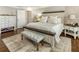 Cozy bedroom features hardwood floors, a plush rug, and a comfortable bed with neutral bedding and a decorative bench at 3176 Crestmont Nw Way, Kennesaw, GA 30152