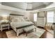 A bedroom with lots of natural light, a padded bench, hardwood floors, and an upholstered headboard at 3176 Crestmont Nw Way, Kennesaw, GA 30152