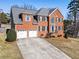 Inviting red brick home featuring a two-car garage and a meticulously maintained lawn at 3176 Crestmont Nw Way, Kennesaw, GA 30152