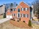Charming red brick home featuring a two-car garage and a beautifully landscaped front entrance at 3176 Crestmont Nw Way, Kennesaw, GA 30152