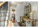 Hallway features hardwood floors, a console table with decorative items, and staircase with iron spindles at 3176 Crestmont Nw Way, Kennesaw, GA 30152