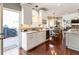 Bright kitchen area with white cabinets, wine storage, stainless steel sink, and wood floors at 3176 Crestmont Nw Way, Kennesaw, GA 30152