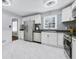 Bright kitchen with modern stainless steel appliances, white cabinets, black countertop, and marble floors at 3535 Warbler Dr, Decatur, GA 30034