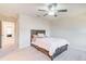 Cozy bedroom featuring soft carpet, ceiling fan, and adjacent access to another room at 5652 Plain Field Ln, Lilburn, GA 30047