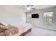 Bright bedroom features plush carpet, ceiling fan, two windows and a wall-mounted television at 5652 Plain Field Ln, Lilburn, GA 30047