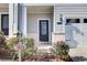 Close up of a stylish front entry with glass door and manicured landscaping at 5652 Plain Field Ln, Lilburn, GA 30047