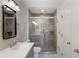 Bathroom with walk-in shower, gray tile, grab bar and single sink vanity at 10104 Windrush Ln, Alpharetta, GA 30009