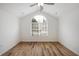 Bright bedroom with vaulted ceiling, large arched window and wood-look floors at 10104 Windrush Ln, Alpharetta, GA 30009