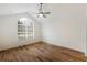 Bright bedroom with vaulted ceiling, large arched window and wood-look floors at 10104 Windrush Ln, Alpharetta, GA 30009