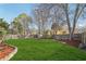 Large, landscaped backyard with a well-maintained lawn, privacy fence, mature trees, and mulch at 10475 Willow Meadow Cir, Alpharetta, GA 30022