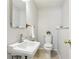 Powder room featuring a toilet, pedestal sink, mirror, towel bar, and neutral paint at 10475 Willow Meadow Cir, Alpharetta, GA 30022