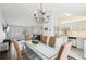 Dining area with a glass top table and modern chandelier, open to living room and updated kitchen with granite countertops at 10475 Willow Meadow Cir, Alpharetta, GA 30022