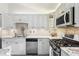 Well-equipped kitchen with stainless steel appliances, stylish cabinetry, tile backsplash, and sleek granite countertops at 10475 Willow Meadow Cir, Alpharetta, GA 30022