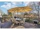 Outdoor patio with large umbrella, outdoor dining furniture, and views of mature trees and blue sky at 10475 Willow Meadow Cir, Alpharetta, GA 30022