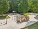 Community playground with multiple play structures, swing sets, and a sandbox surrounded by mature trees at 10475 Willow Meadow Cir, Alpharetta, GA 30022