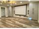 Basement showcasing custom cabinets, wood-look flooring, and a large movie screen at 6787 Hembree Dr, Austell, GA 30168