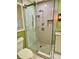 This bathroom features a glass enclosed shower, light green walls, and a white toilet at 6787 Hembree Dr, Austell, GA 30168