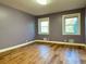 Bedroom with hardwood floors, two windows, and light purple walls at 6787 Hembree Dr, Austell, GA 30168
