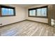 Bedroom featuring hard surface flooring, two windows, and gray trim at 6787 Hembree Dr, Austell, GA 30168