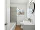Bright bathroom features wood floors, gray tiled shower, and a round mirror at 1189 Kathryn Cir, Forest Park, GA 30297