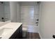 Bathroom featuring a dark vanity, white counter tops, wood flooring, and a shower at 4371 Portsbrook Ave, Snellville, GA 30039