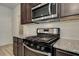 Stainless steel range and microwave accent dark cabinets and granite counters in this modern kitchen at 4371 Portsbrook Ave, Snellville, GA 30039
