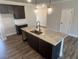 Kitchen island offers granite countertops, stainless sink, ample cabinet space, and decorative pendant lighting at 4371 Portsbrook Ave, Snellville, GA 30039