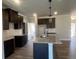 Charming kitchen with an island, dark cabinets, granite counters, and stainless steel appliances at 4371 Portsbrook Ave, Snellville, GA 30039