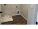 Small laundry room with wood-look flooring, neutral paint, and door to utility closet at 4371 Portsbrook Ave, Snellville, GA 30039