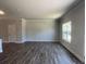 Well-lit living room features luxury vinyl flooring, crown molding, and a large window for ample natural light at 4371 Portsbrook Ave, Snellville, GA 30039