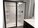 White Shower featuring black trim, built-in shelving, and shower seat at 4371 Portsbrook Ave, Snellville, GA 30039