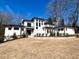 Beautiful white brick home with modern design elements, a well-maintained lawn, and pathway to the front door at 4524 Mystic Dr, Sandy Springs, GA 30327