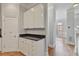 Kitchen area with white cabinets, granite countertops, and hardwood floors leading to the living room at 1555 Mosaic Way # 1555, Smyrna, GA 30080