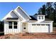 New construction home with white siding, black roof, and an attached garage and unfinished yard at 156 Easton Park Blvd, Dallas, GA 30157