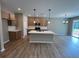 Open-concept kitchen boasts an island, wood floors, and abundant natural light at 156 Easton Park Blvd, Dallas, GA 30157