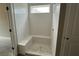 Bathroom shower with tile surround, built-in bench, and window at 156 Easton Park Blvd, Dallas, GA 30157
