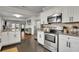 Open kitchen with granite counters, white cabinets, stainless steel appliances, and view to living area at 265 Haas Se Ave, Atlanta, GA 30316