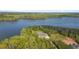 Scenic aerial view shows a luxurious home surrounded by lush greenery and a stunning lake at 840 Old Driver Road, Whitesburg, GA 30185