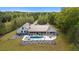 Beautiful aerial view of a modern farmhouse with a pool, patio, and vast lawn, surrounded by mature trees at 840 Old Driver Road, Whitesburg, GA 30185