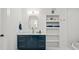 Well-lit bathroom features a blue vanity with gold hardware, marble countertop, and open shelving at 840 Old Driver Road, Whitesburg, GA 30185