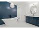 Elegant bathroom boasts a soaking tub, blue accent wall, and stylish vanity with marble countertop at 840 Old Driver Road, Whitesburg, GA 30185