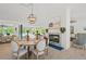 Dining area with a fireplace, modern chandelier, and views of the outdoor pool and patio at 840 Old Driver Road, Whitesburg, GA 30185