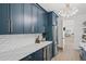 A modern butler's pantry features navy cabinets, white countertops, and stylish fixtures, a sleek design at 840 Old Driver Road, Whitesburg, GA 30185
