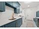 Well-lit laundry room with bright blue cabinets, modern washer and dryer, and decorative herringbone backsplash at 840 Old Driver Road, Whitesburg, GA 30185