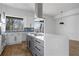 Modern kitchen features a gas cooktop, stainless steel appliances, white cabinets, and a blue backsplash at 147 Hutchinson Ne St, Atlanta, GA 30307