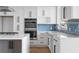 Close-up of kitchen details: stainless steel oven, cooktop, sink, and blue tile backsplash at 147 Hutchinson Ne St, Atlanta, GA 30307