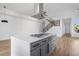 Spacious kitchen island with gas cooktop and modern vent hood, adjacent to open living space at 147 Hutchinson Ne St, Atlanta, GA 30307
