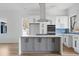 Modern kitchen with white cabinets, stainless steel appliances, and a central island with a cooktop at 147 Hutchinson Ne St, Atlanta, GA 30307