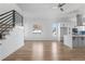 Spacious living room with modern kitchen, hardwood floors, and staircase with metal railing at 147 Hutchinson Ne St, Atlanta, GA 30307