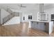 Open-concept living space with hardwood floors, modern stairs, and a stylish kitchen island at 147 Hutchinson Ne St, Atlanta, GA 30307